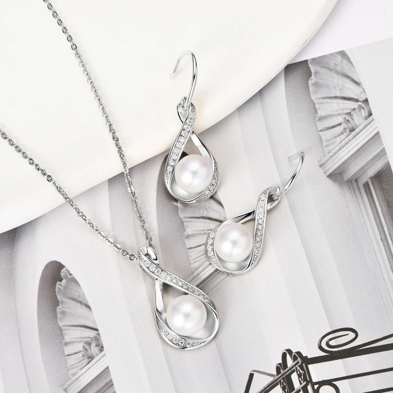 Luminous freshwater pearl pendant & earrings in sterling silver with sparkling moissanite.