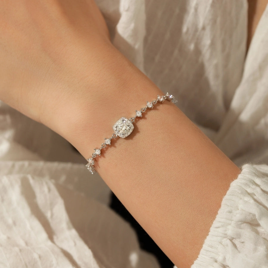 Elegant bracelet with moissanite center stone and diamond accents, silver setting.