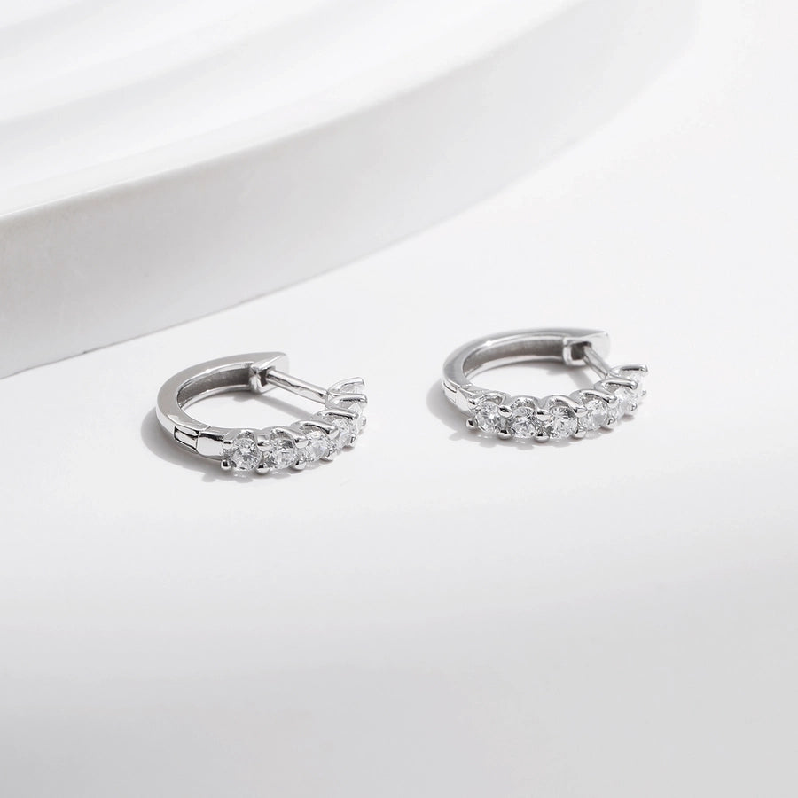 Dazzling moissanite diamond earrings, set in sleek sterling silver hoops.